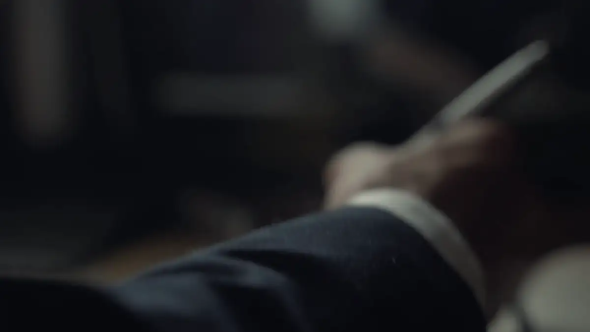 Hands turning the pages of a notebook in low light