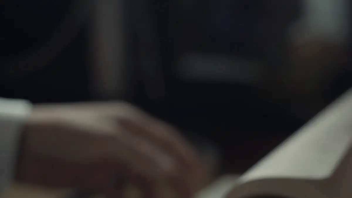 Hands turning the pages of a notebook in low light