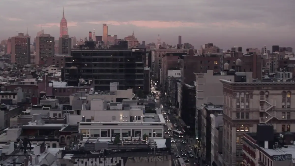 City rooftops under a pink sunset sky