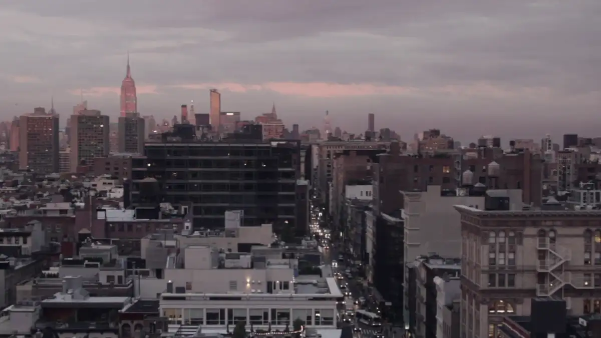 City rooftops under a pink sunset sky